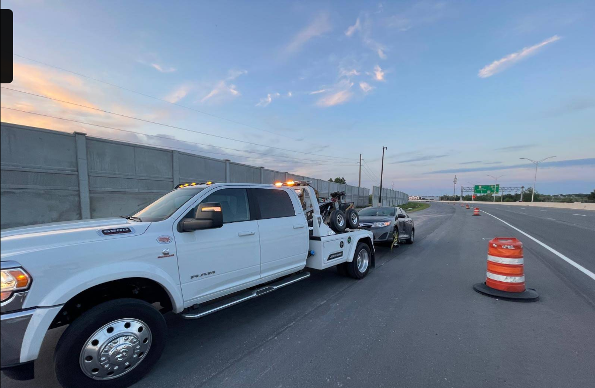 Tow truck recovering a sedan on a Florida highway