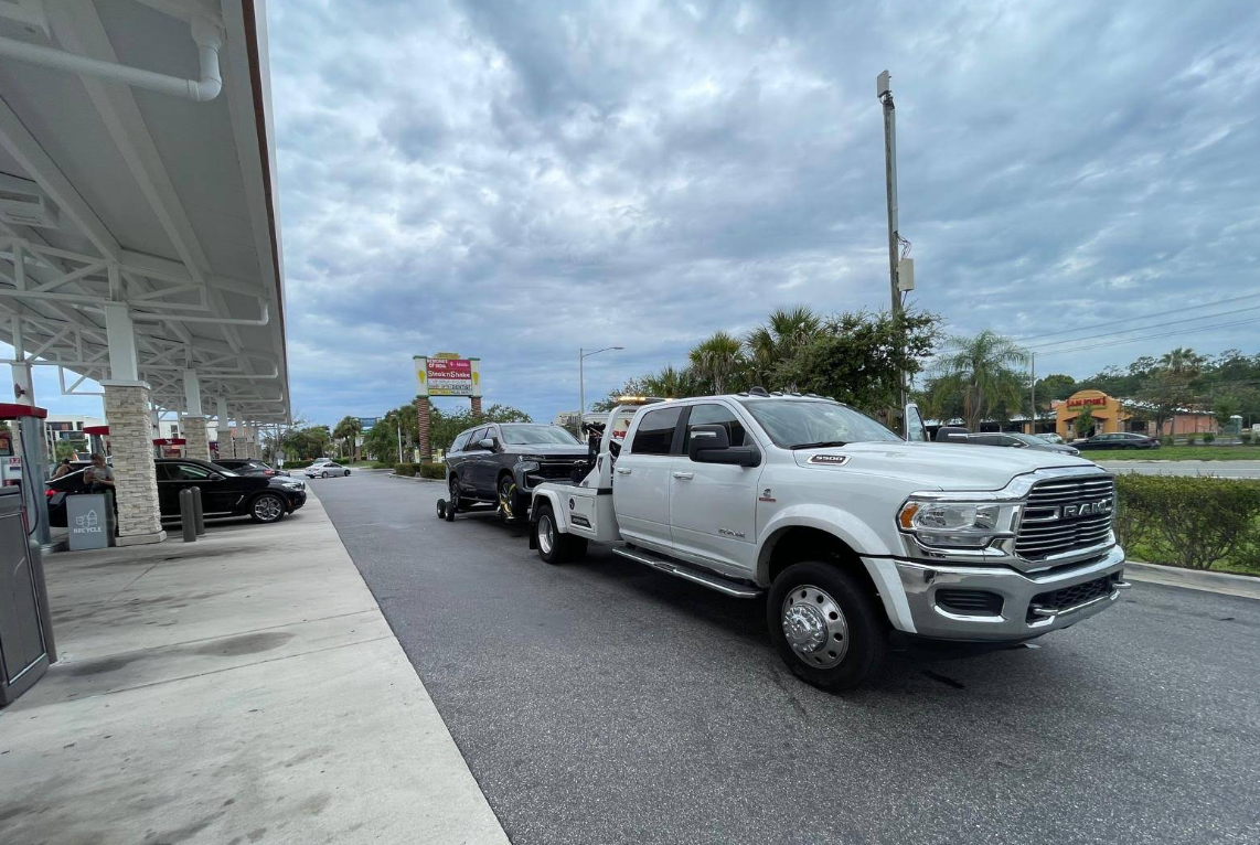 RAM flatbed tow truck transporting a vehicle